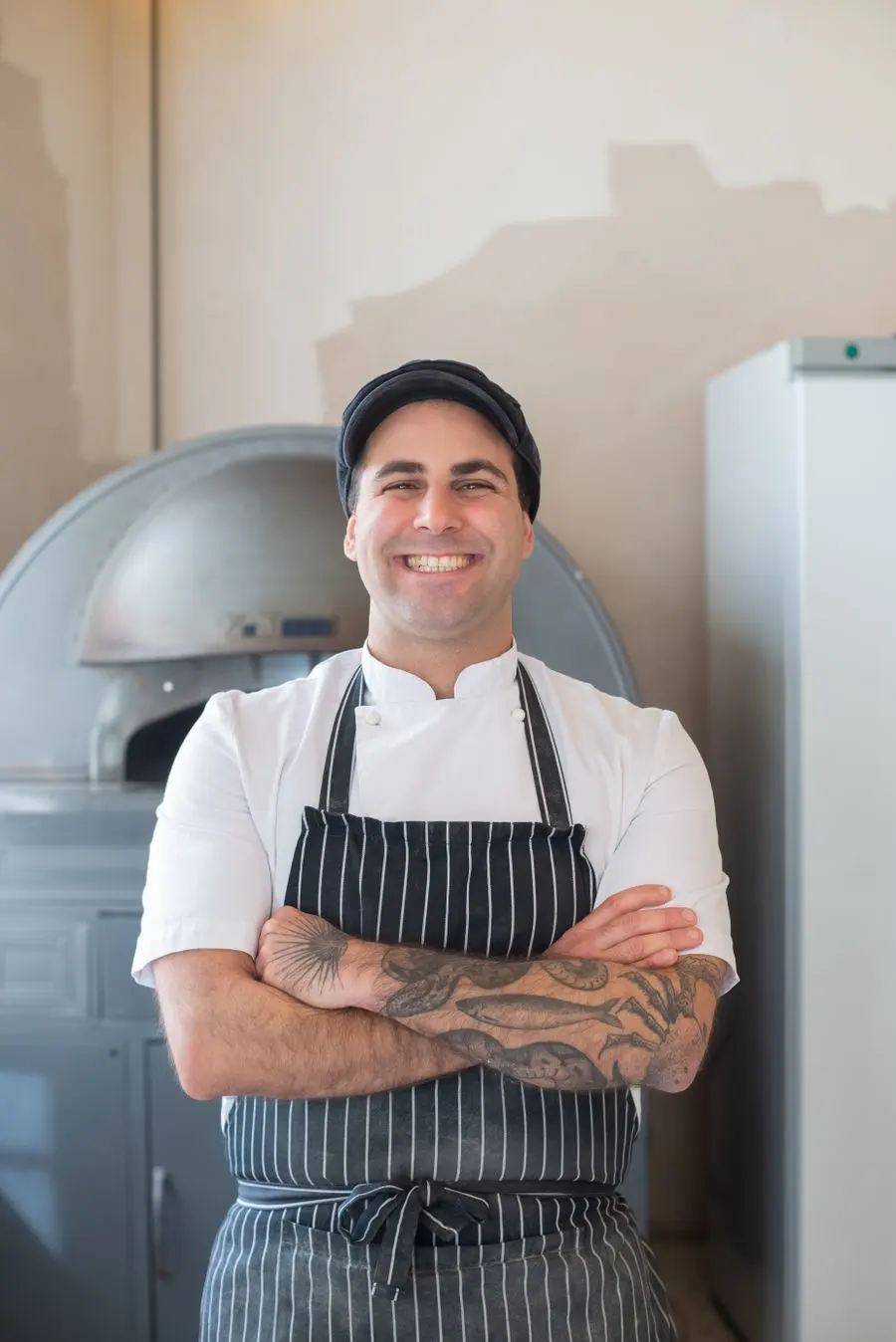 A baker in an apron standing in his bakery