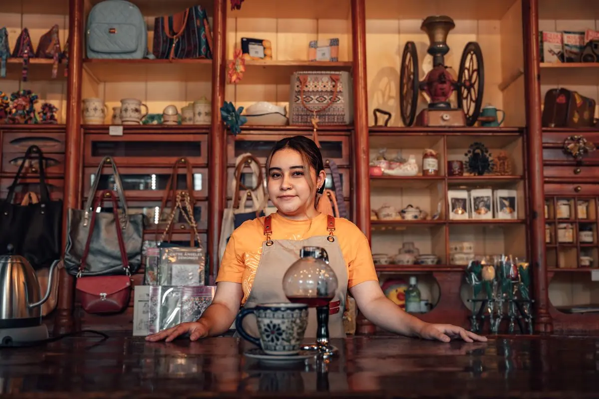 A café owner standing behind her counter