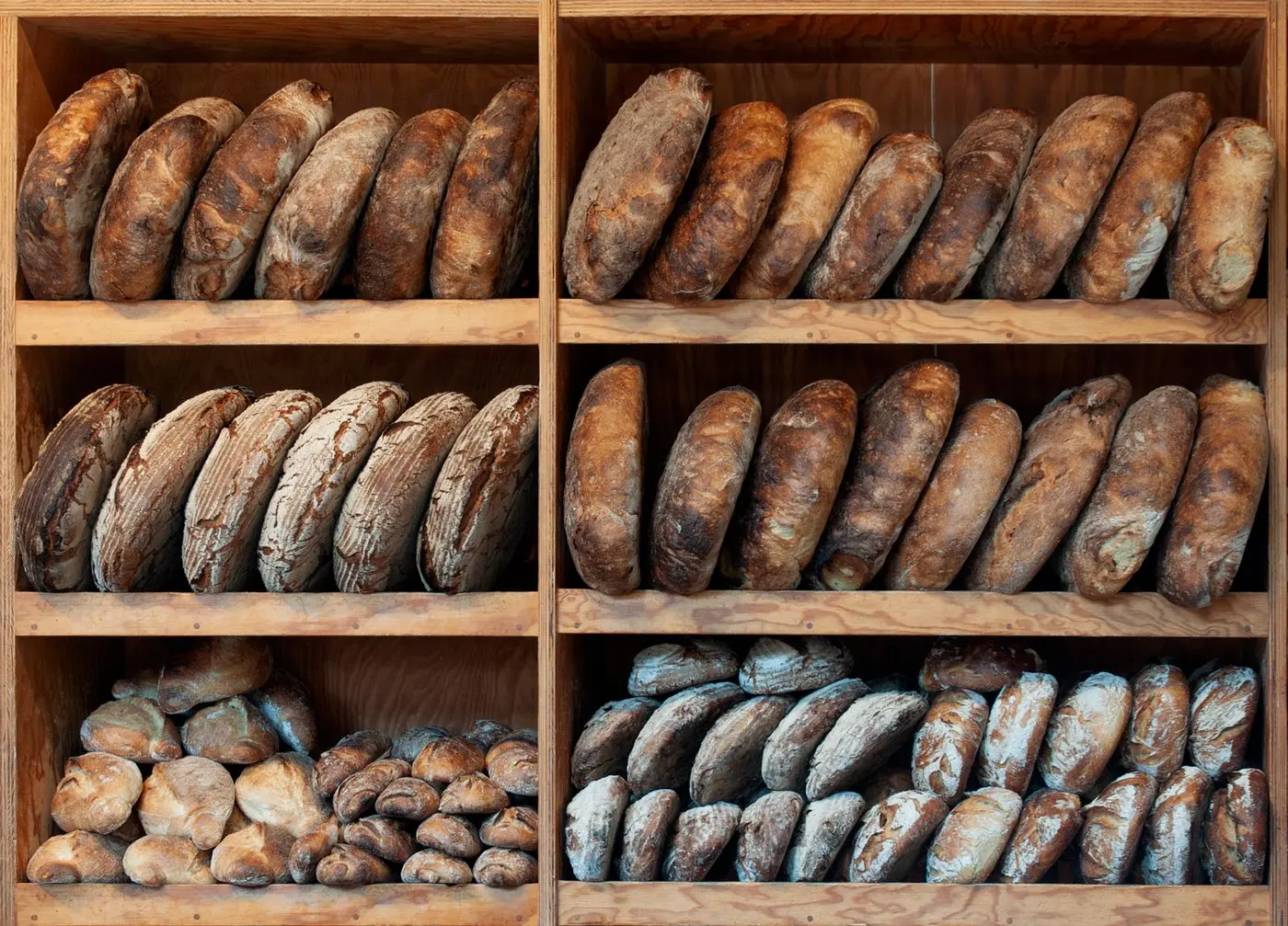 Loaves of artisan bread on wooden shelves